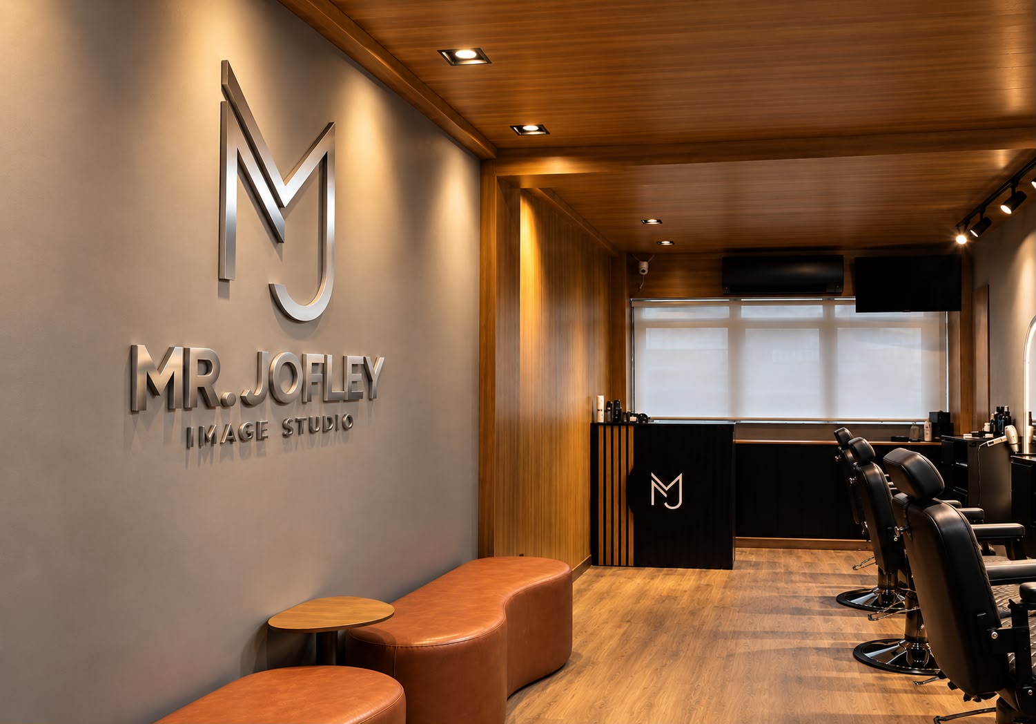 Vista ampla do Mr. Jofley Image Studio, com logo na parede, poltronas e estações de atendimento